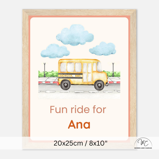 A personalized school bus art print in a light wood frame, featuring a watercolor illustration of a yellow school bus under blue clouds with the text 'Fun ride for Ana' and size text '20x25cm / 8x10"' at the bottom.
