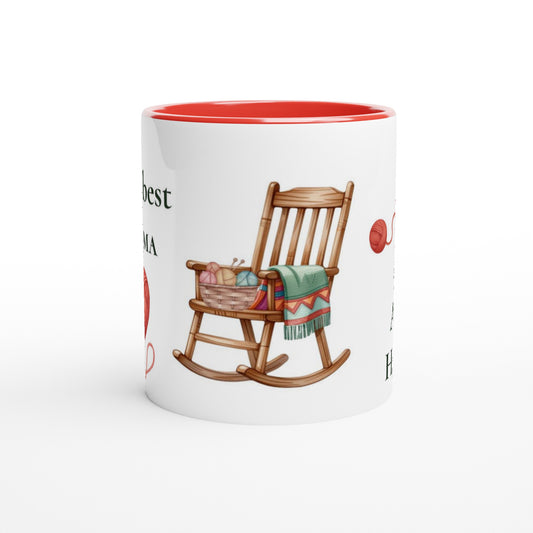 A white ceramic mug with a red interior, featuring a printed illustration of a wooden rocking chair with a green blanket and red yarn balls on a white background.