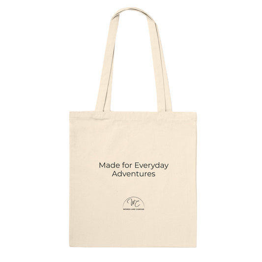 A natural canvas tote bag with black printed text reading 'Made for Everyday Adventures' and a small circular logo below, shown on a plain white background.