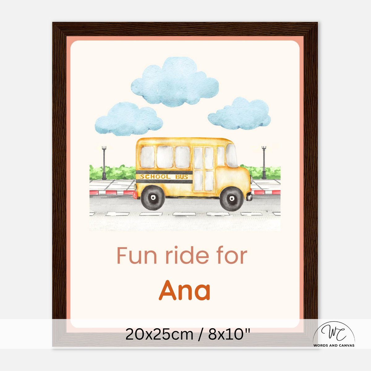 A personalized framed school bus art print. The print features a watercolor-style yellow school bus on a road with blue clouds and green trees, with the customizable text 'Fun ride for Ana' below.