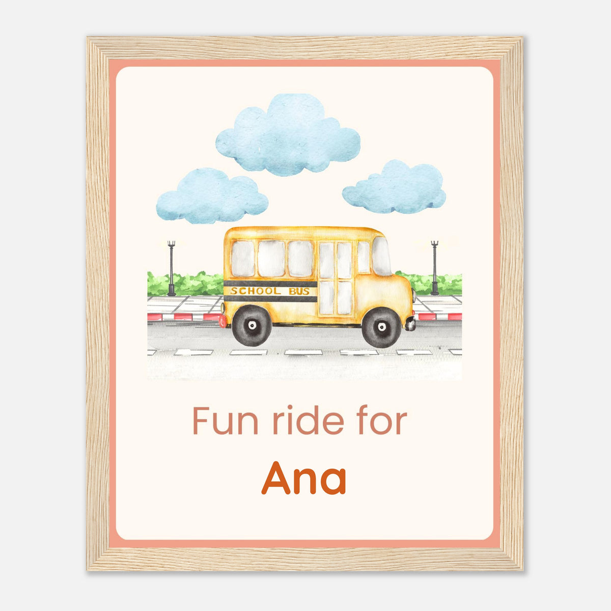 A personalized wooden picture frame print featuring a watercolor illustration of a yellow school bus under blue clouds, with the text 'Fun ride for Ana' in orange. The frame has a light natural wood finish and is set against a neutral light gray background.