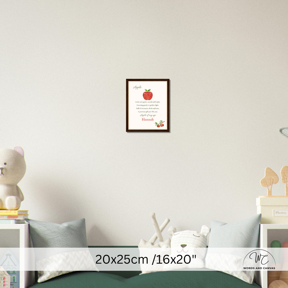 A framed apple-themed nursery wall art print hangs on a light grey wall above a bed. The print features a red apple illustration and text 