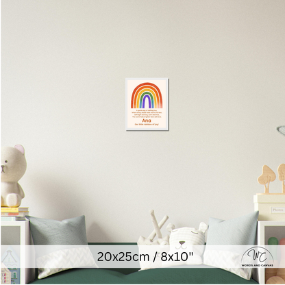 A personalized rainbow canvas print displayed on a light gray wall above a child's bed. The canvas features a colorful rainbow