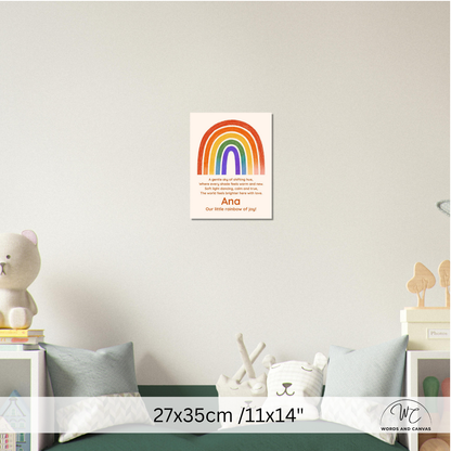 A personalized rainbow canvas print hanging on a light gray wall above a bed. The canvas features a colorful rainbow with the text 
