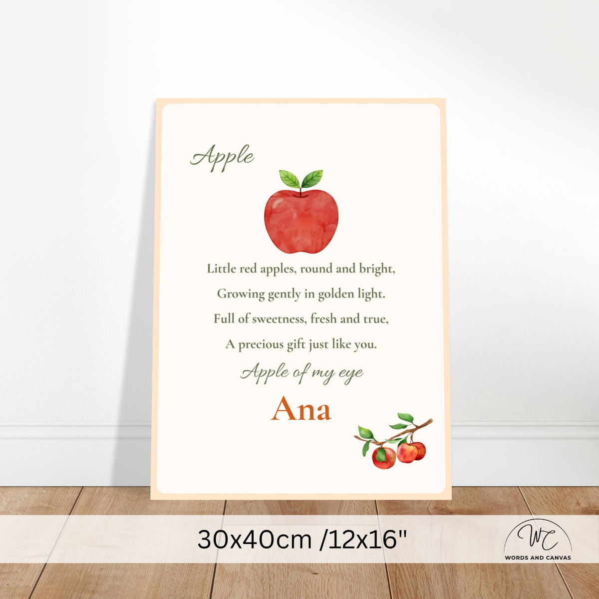 A personalized nursery art print featuring a red watercolor apple and the poem 'Apple' with the name 'Ana' and a matching apple illustration. The print is displayed leaning against a white wall on a light wood floor, with a size overlay at the bottom indicating 30x40cm / 12x16".