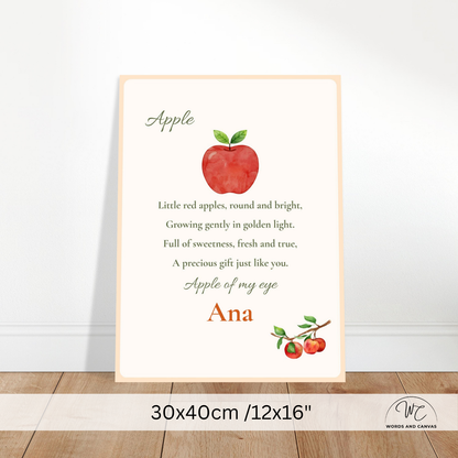 A personalized nursery art print featuring a red watercolor apple and the poem 'Apple' with the name 'Ana' and a matching apple illustration. The print is displayed leaning against a white wall on a light wood floor, with a size overlay at the bottom indicating 30x40cm / 12x16".