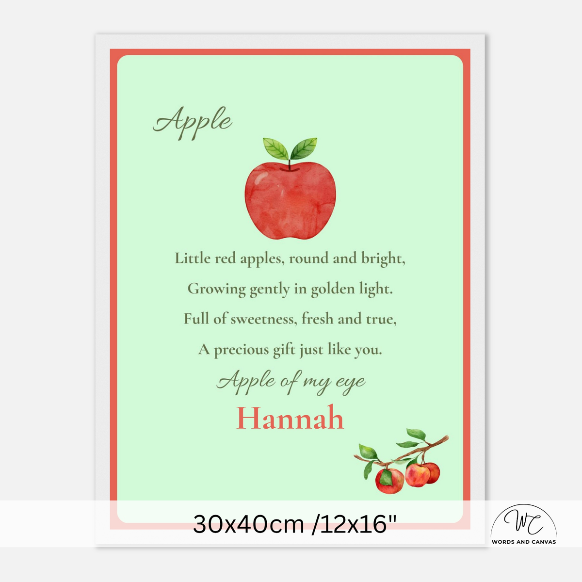 A personalized apple-themed nursery print with a light mint green background, a red watercolor apple illustration, and the text 'Apple of my eye' and 'Hannah'. The print is shown with a white frame and a size label at the bottom reading 30x40cm /12x16".