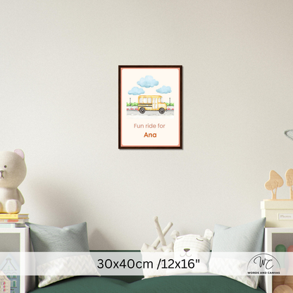 A framed personalized children's wall art print hangs on a light gray wall above a bed. The print shows a yellow school bus under blue clouds with the text 'Fun ride for Ana'.