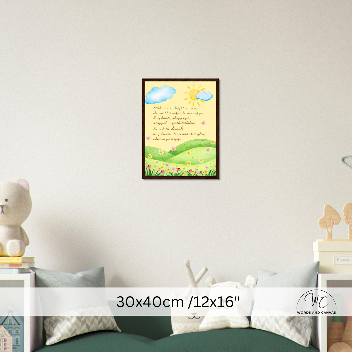 A framed children's wall art print hangs on a light gray wall above a green sofa in a styled room. The print shows a sunny pastel landscape with blue clouds, a yellow sun, green hills, and a poem printed in the center.
