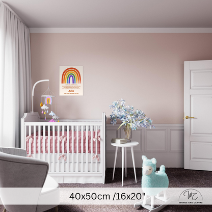 A nursery room scene showing a framed rainbow wall art print hanging above a white crib. The room has blush pink walls, white wainscoting, a white crib, a small white side table with blue flowers, a plush toy, and a visible watermark/logo at the bottom right reading Words Are Canvas.