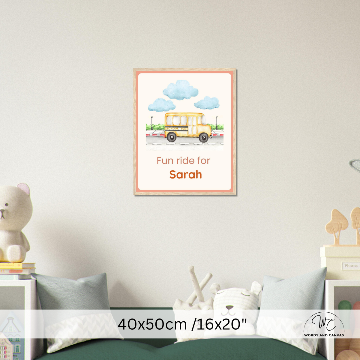 A personalized children's framed wall art print featuring a yellow school bus and blue clouds above the text 'Fun ride for Sarah', shown hanging on a light wall above a bed in a styled bedroom setting. A size overlay reads 40x50cm / 16x20".