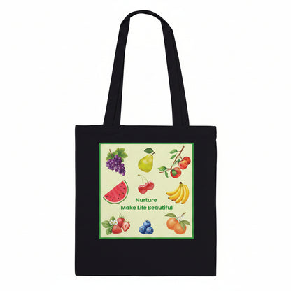 A black canvas tote bag with two shoulder straps, featuring a square graphic print on the front. The print showcases various colorful fruits, including grapes, a pear, cherries, watermelon, bananas, strawberries, blueberries, and oranges, with the text 'Nurture Make Life Beautiful' written in green.
