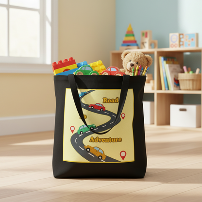 A black tote bag with a large yellow graphic showing a winding road labeled 'Road to Adventure' with toy cars and map pins, standing on a light wood floor in a softly lit children's room.