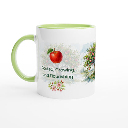 A white ceramic mug with a light green interior and handle, featuring a watercolor-style apple tree illustration and the text 'Rooted, Growing, and Flourishing' on the front.