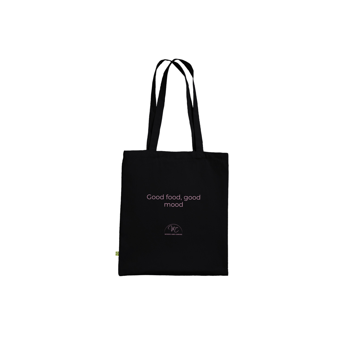 A black canvas tote bag with black handles, featuring the text 'Good food, good mood' in a light pink font and a small circular logo below it.