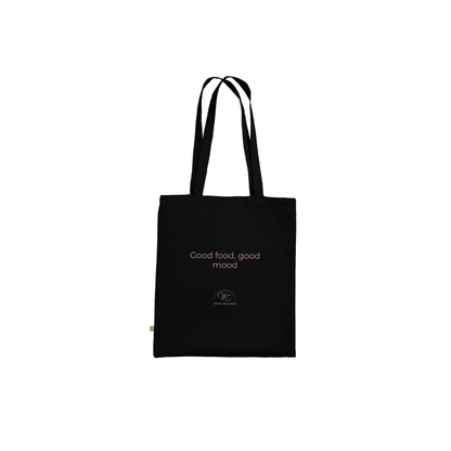 A black canvas tote bag with black handles, featuring the text 'Good food, good mood' in a light pink font and a small circular logo below it.