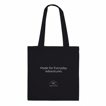 A black canvas tote bag with black printed text and a small circular logo below