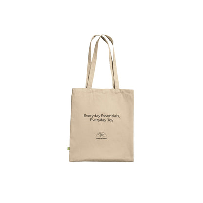 A beige canvas tote bag with black printed text reading 'Everyday essentials, everyday joy' and a small circular logo near the bottom, shown on a plain white background.