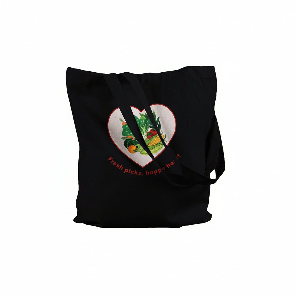 A black canvas tote bag with long shoulder straps, featuring a heart-shaped graphic on the front filled with colorful fruits and vegetables and the text 'Fresh picks, happy heart'.