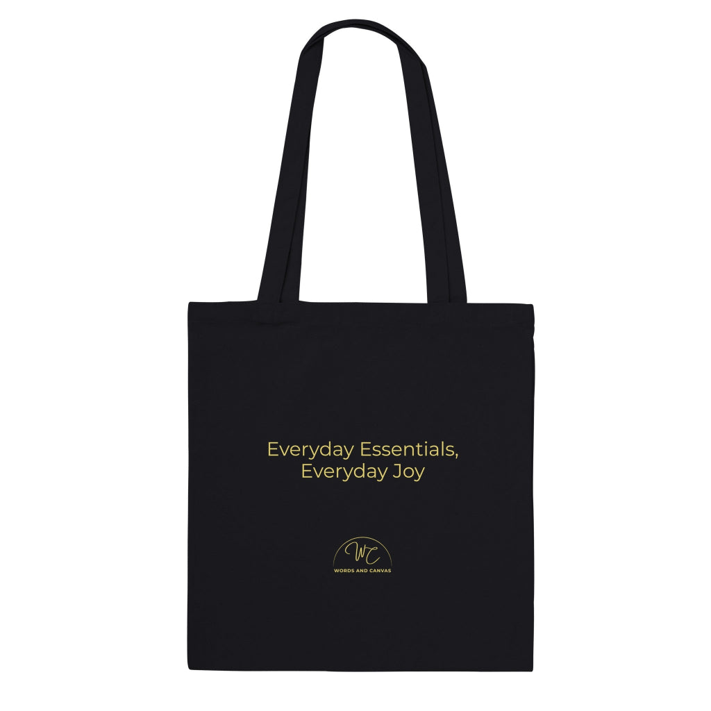 Black tote bag with a quote 'Everyday essentials, everyday joy' on a white background