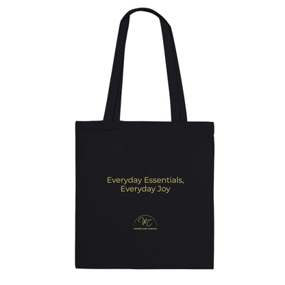 Black tote bag with a quote 'Everyday essentials, everyday joy' on a white background