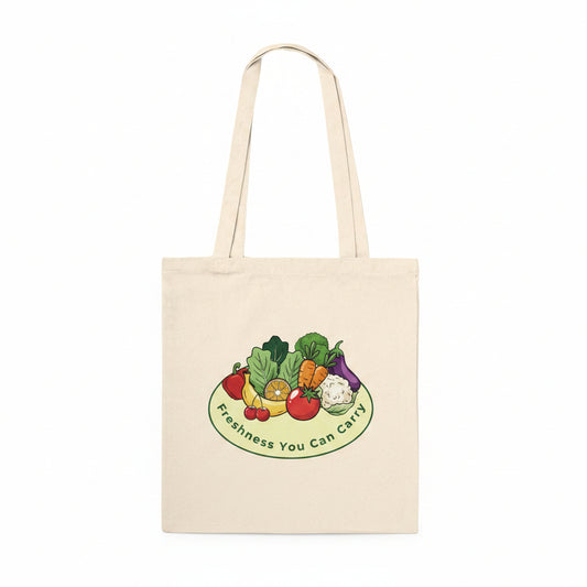 A natural canvas tote bag with dual shoulder straps, featuring a colorful graphic of fresh vegetables on a plate with the text 'Freshness You Can Carry' printed below it, set against a plain white background.