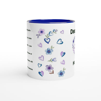 A white ceramic mug with a vibrant blue interior and rim, decorated with watercolor-style purple and blue flowers, hearts, and text on the side.