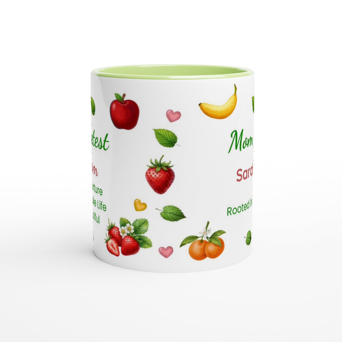 A white ceramic mug with a light green interior, decorated with illustrations of various fruits including strawberries, oranges, bananas, and apples, alongside green text on a white background.