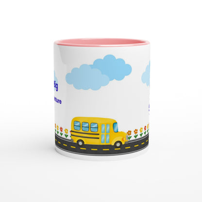 A white ceramic mug with a pink interior, featuring a cartoon illustration of a yellow school bus on a road with blue clouds and flowers.