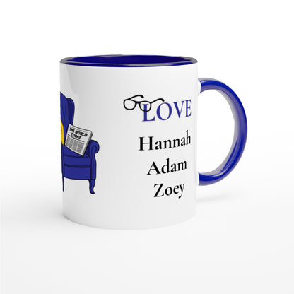 A white ceramic coffee mug with a dark blue interior, handle, and rim. The mug features a graphic of a blue armchair reading a newspaper next to the word 'LOVE' in blue, with the names 'Hannah', 'Adam', and 'Zoey' printed in black below.