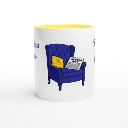 A white ceramic mug with a yellow interior, featuring a cartoon illustration of a blue armchair with a yellow pillow and a newspaper reading 'THE WORLD TODAY'.