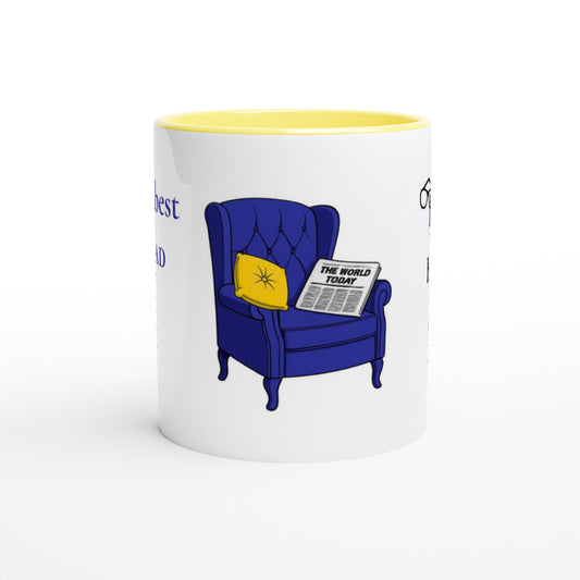 A white ceramic mug with a yellow interior, featuring a cartoon illustration of a blue armchair with a yellow pillow and a newspaper reading 'THE WORLD TODAY'.
