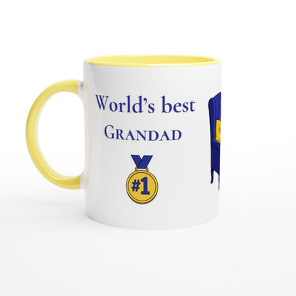A white ceramic mug with a yellow interior and handle, printed with the text 'World's best GRANDAD' in blue, a gold '#1' medal graphic, and part of a blue and yellow ribbon design on a white background.