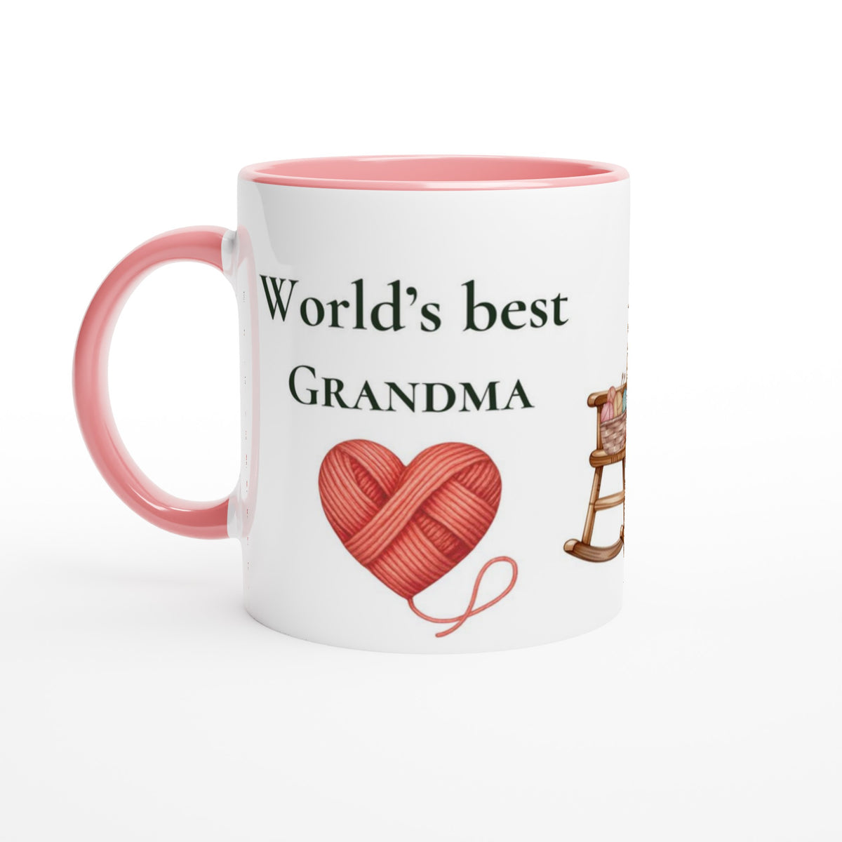 A white ceramic mug with a pink interior and handle, printed with the text 'World's best GRANDMA' above a red heart-shaped yarn ball and a small rocking chair illustration.