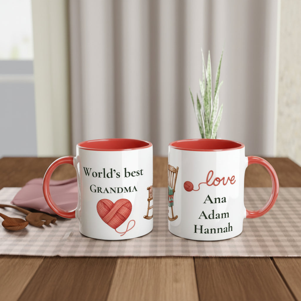 Two personalized ceramic mugs with red interiors and handles, displayed on a wooden table. The mug on the left reads 'World's best GRANDMA' with a red heart-shaped yarn ball graphic.