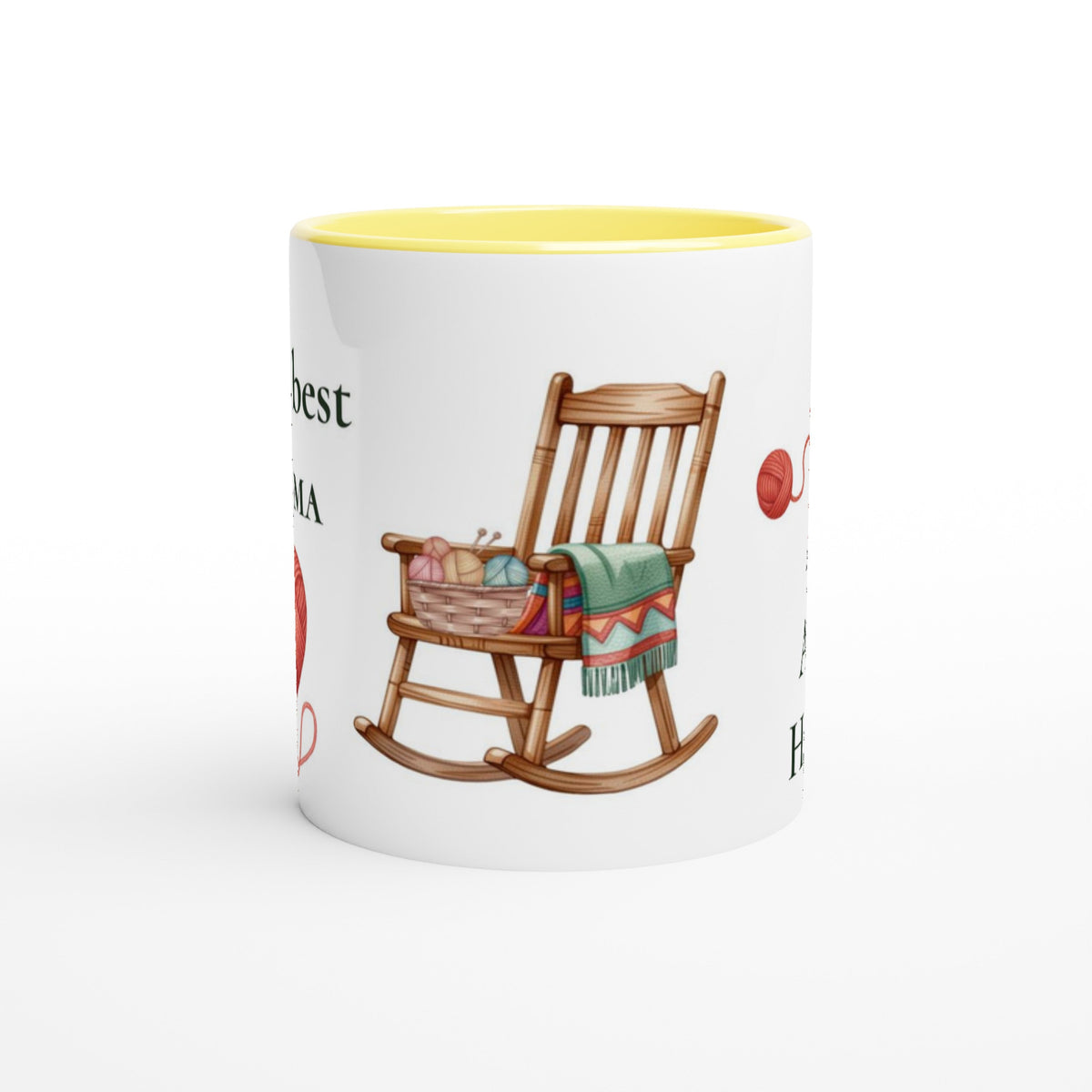 A white ceramic coffee mug with a yellow interior, featuring a printed illustration of a wooden rocking chair with a colorful knit blanket and yarn basket, alongside partial red and black text.