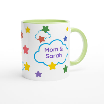 A white ceramic mug with a light green handle and interior, decorated with colorful stars and a blue cloud outline containing the text 'Mom & Sarah' in purple, on a white background.