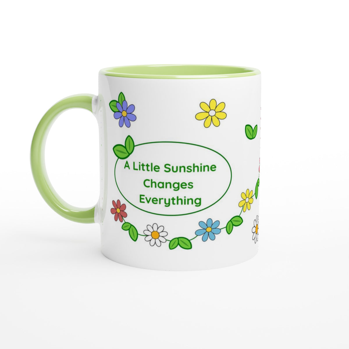 A white ceramic mug with a light green handle and interior, decorated with colorful cartoon flowers and a green oval that reads 'A Little Sunshine Changes Everything'.