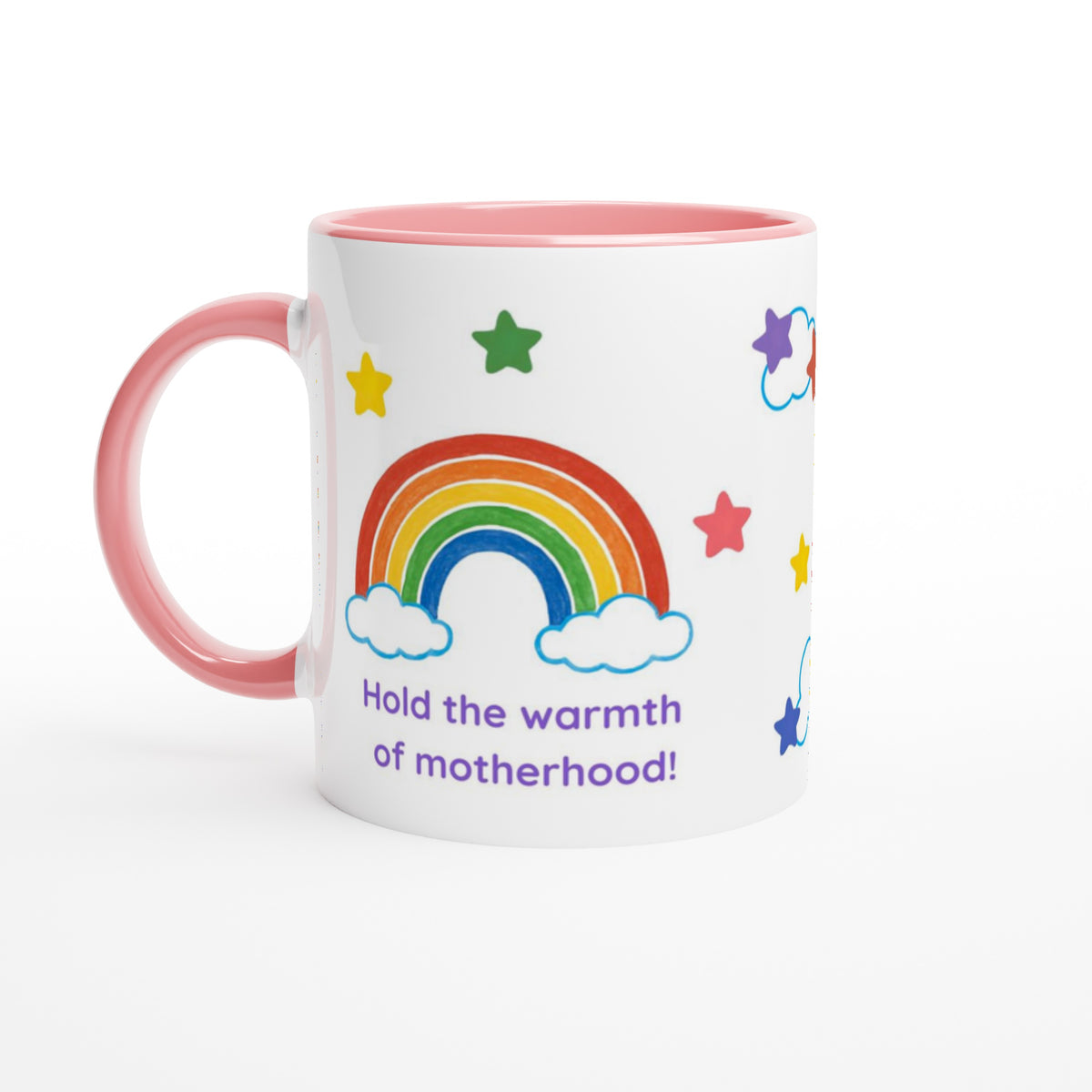 A white ceramic mug with a pink handle and pink interior, decorated with a colorful rainbow, stars, clouds, and the text 'Hold the warmth of motherhood!' in purple, on a clean white background.