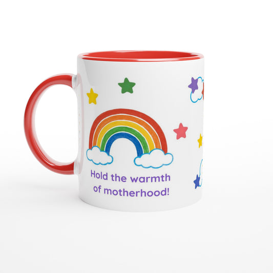 A white ceramic mug with a red interior and red handle, decorated with a colorful rainbow, stars, clouds, and the text 'Hold the warmth of motherhood!' in purple, shown on a clean white background.