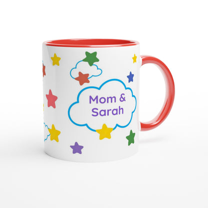 A white ceramic mug with a red interior and red handle, decorated with colorful stars and a blue cloud outline containing the text 'Mom & Sarah' in purple, shown on a white background.