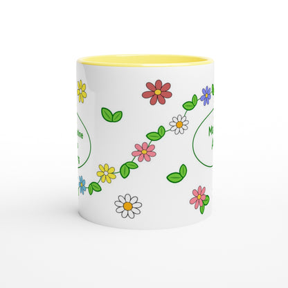 A white ceramic mug with a yellow interior, decorated with a colorful pattern of small flowers and green leaves.