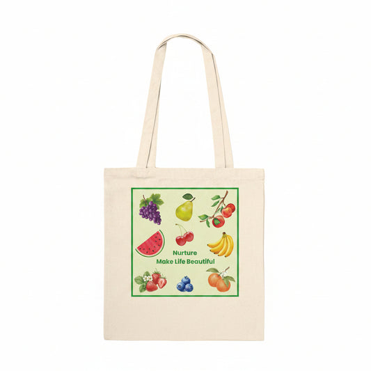 A natural beige canvas tote bag with two shoulder straps, featuring a colorful square graphic print on the front. The graphic shows various fruits (grapes, pear, cherries, watermelon, bananas, blueberries, oranges) with the text 'Nurture Make Life Beautiful' in green.