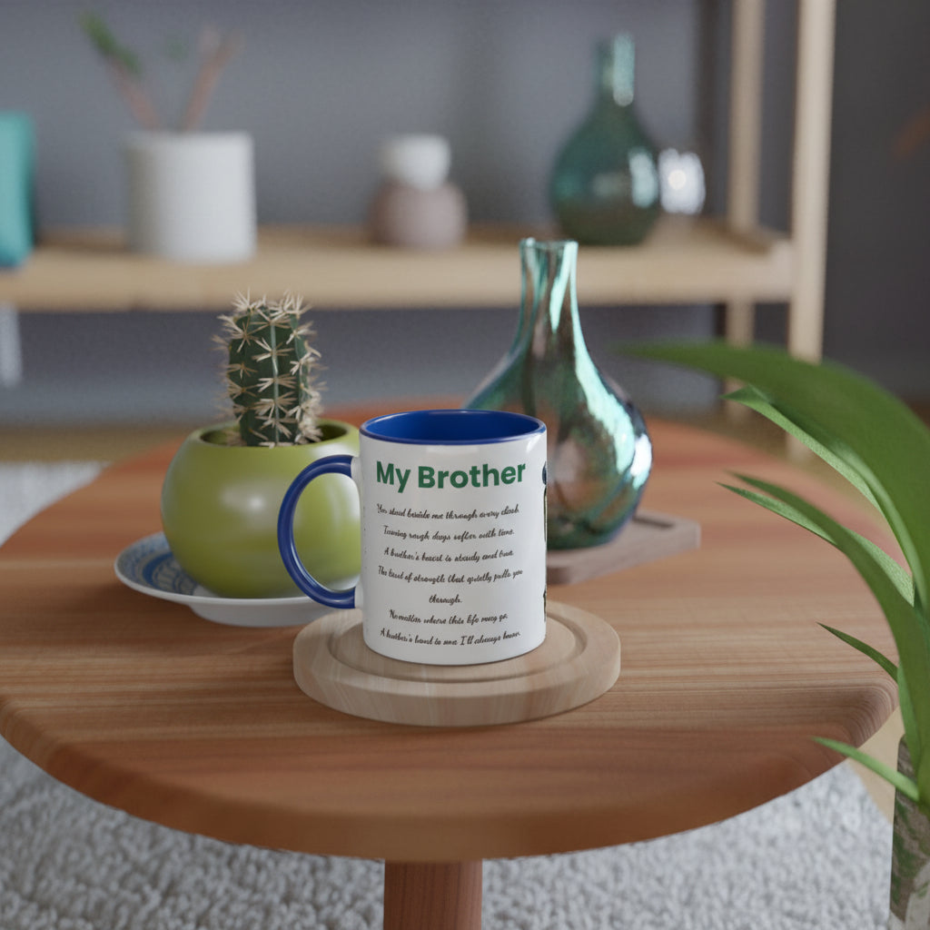 A white ceramic mug with a blue handle and rim sits on a round wooden coaster on a light wood table. The mug is printed with the text 'My Brother' 