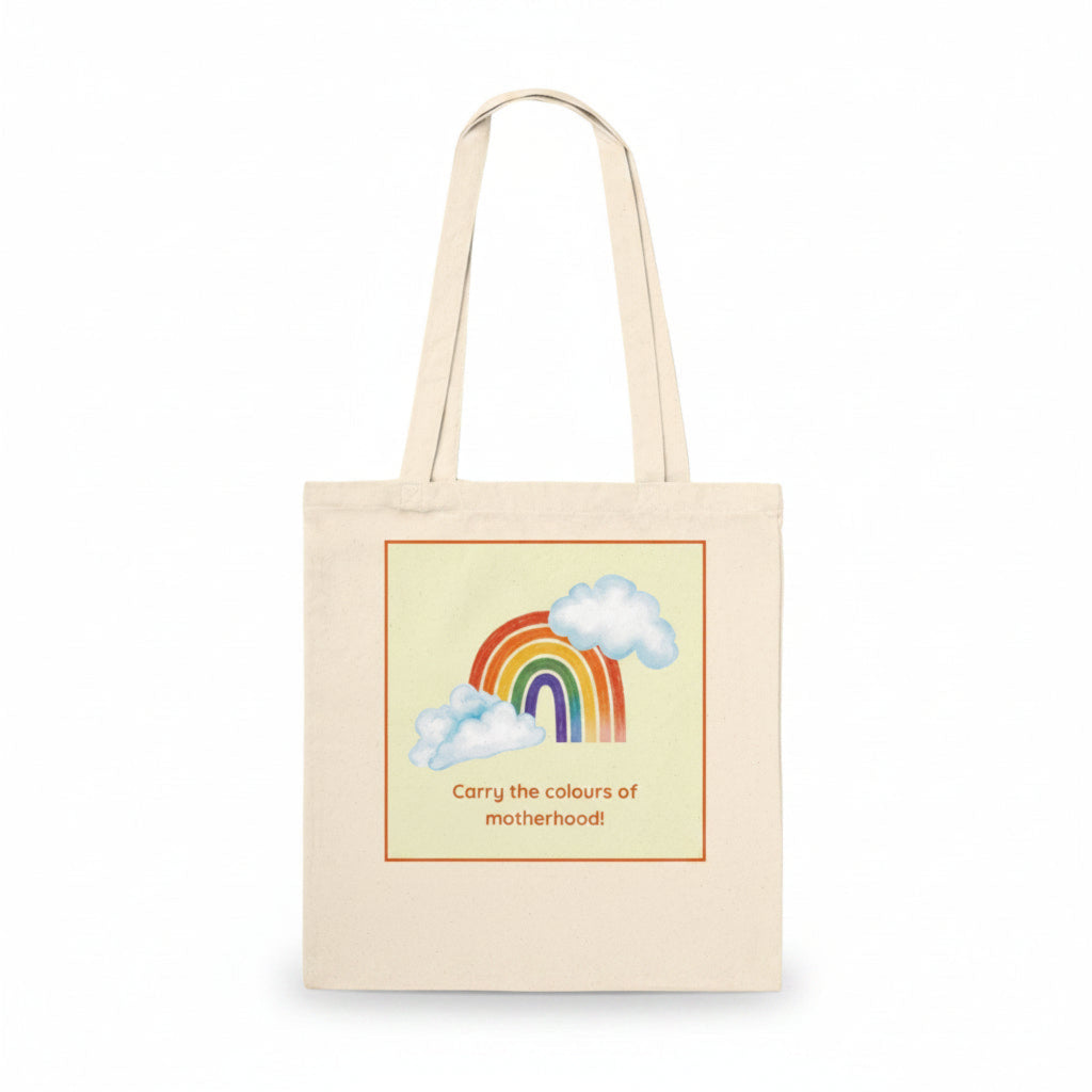 A natural canvas tote bag with a printed graphic of a rainbow, clouds, and the text 'Carry the colours of motherhood!' on a clean white background.