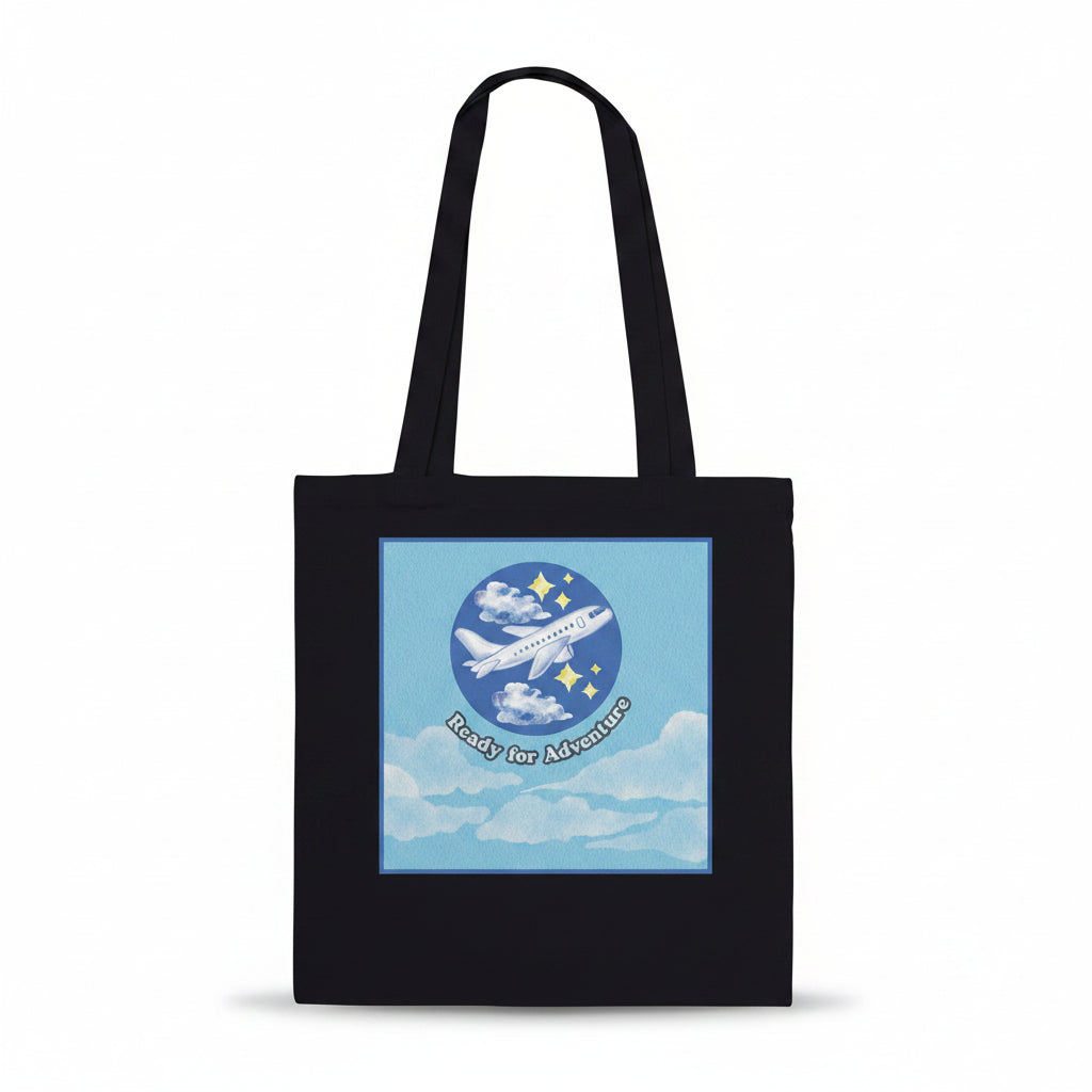 A black canvas tote bag with two shoulder straps, featuring a square graphic print on the front. The graphic shows a light blue sky with white clouds, a white airplane
