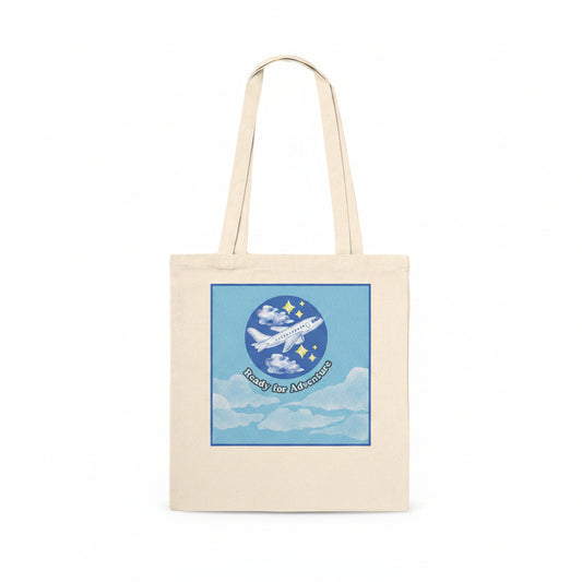 A natural canvas tote bag with a square graphic print on the front. With the text 'Ready for Adventure' below.