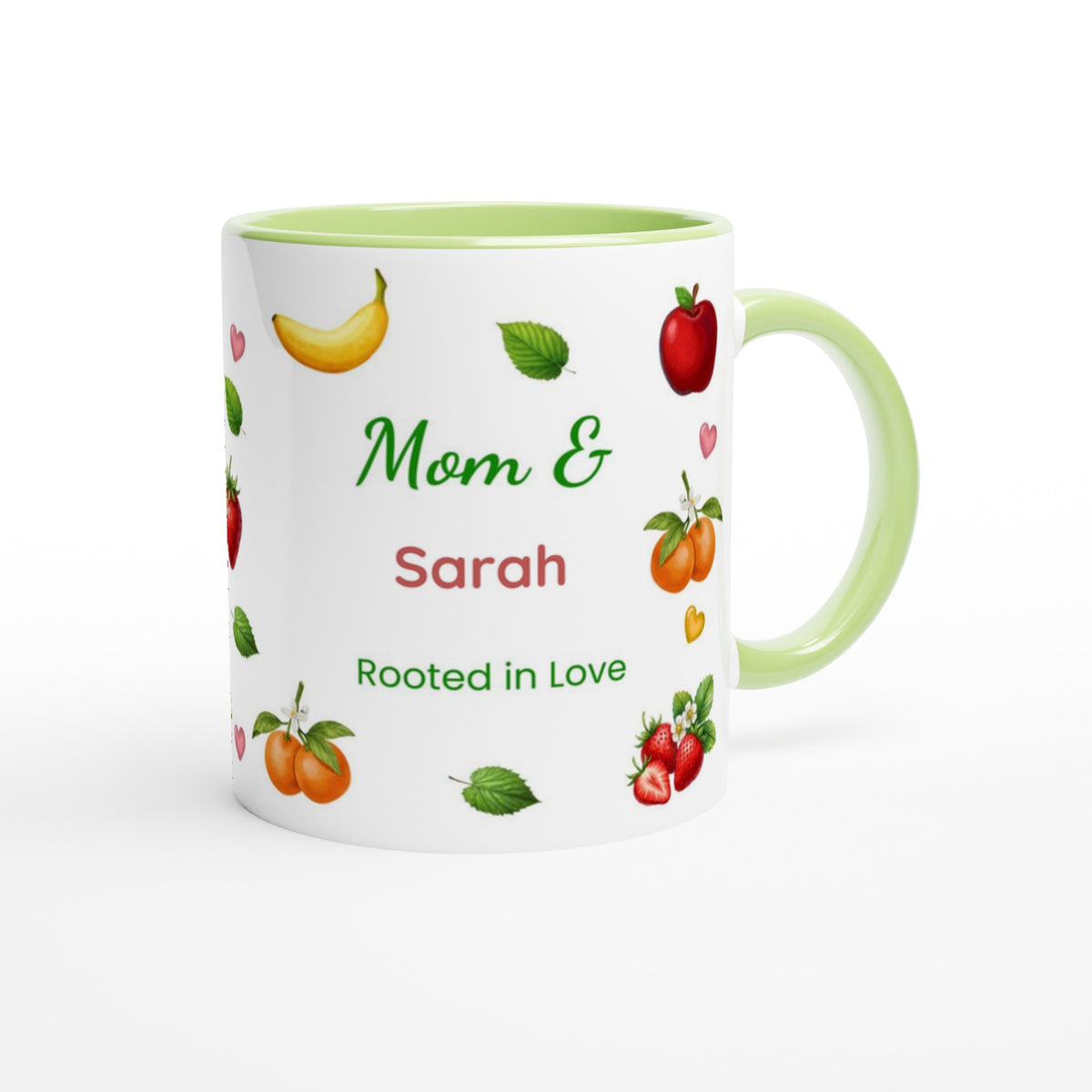 A white ceramic mug with a light green handle and interior, decorated with illustrations of fruits and the personalized text 'Mom & Sarah Rooted in Love'.