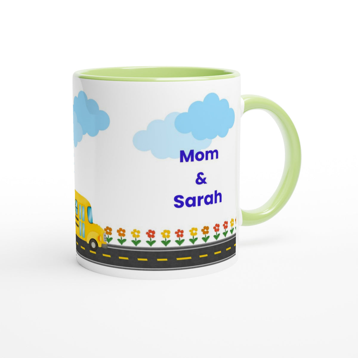 A white ceramic mug with a light green handle and interior, decorated with a cartoon school bus, flowers, a road, and the text 'Mom & Sarah' in blue, shown on a white background.