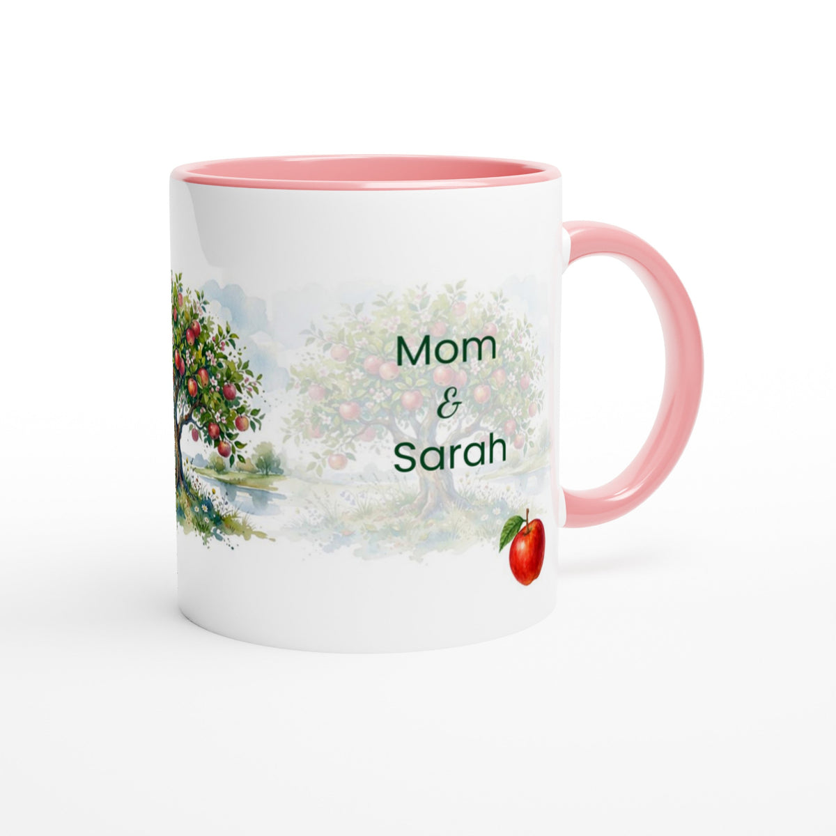 A white ceramic mug with a pink interior and handle, featuring a watercolor-style apple tree illustration and the personalized text 'Mom & Sarah' on the front.